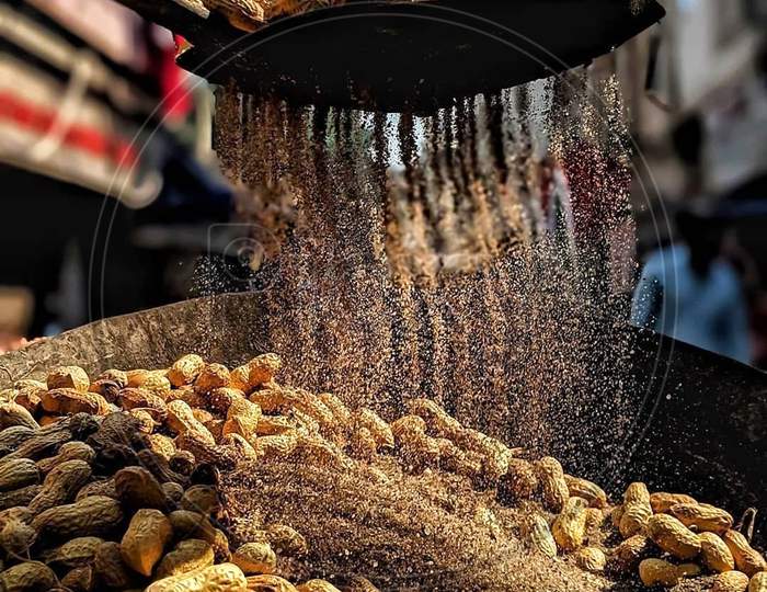 Roasting Ground nuts in market in sand for sale