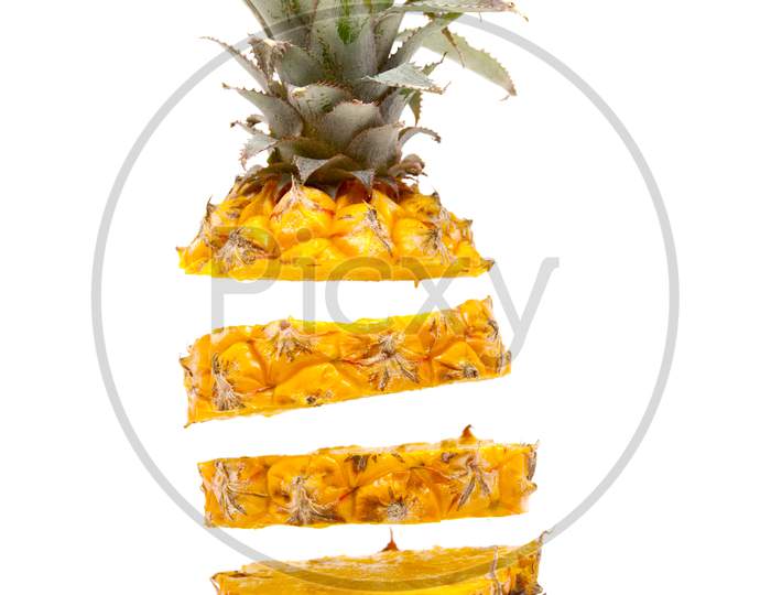 ripe delicious baby pineapple slices floating on white background