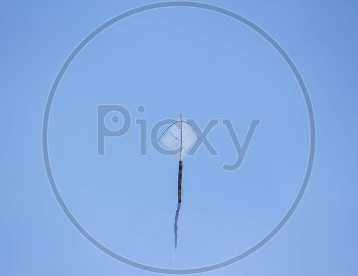Kite Flying In The Wind. Kite Flying Against Sky Isolated On Blue Background.