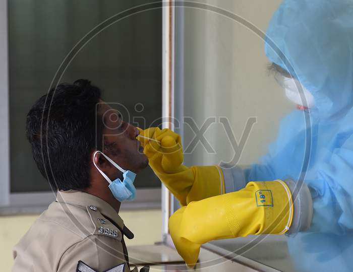 Medics wearing protective suits collect swab samples for the COVID-19 test in Chennai