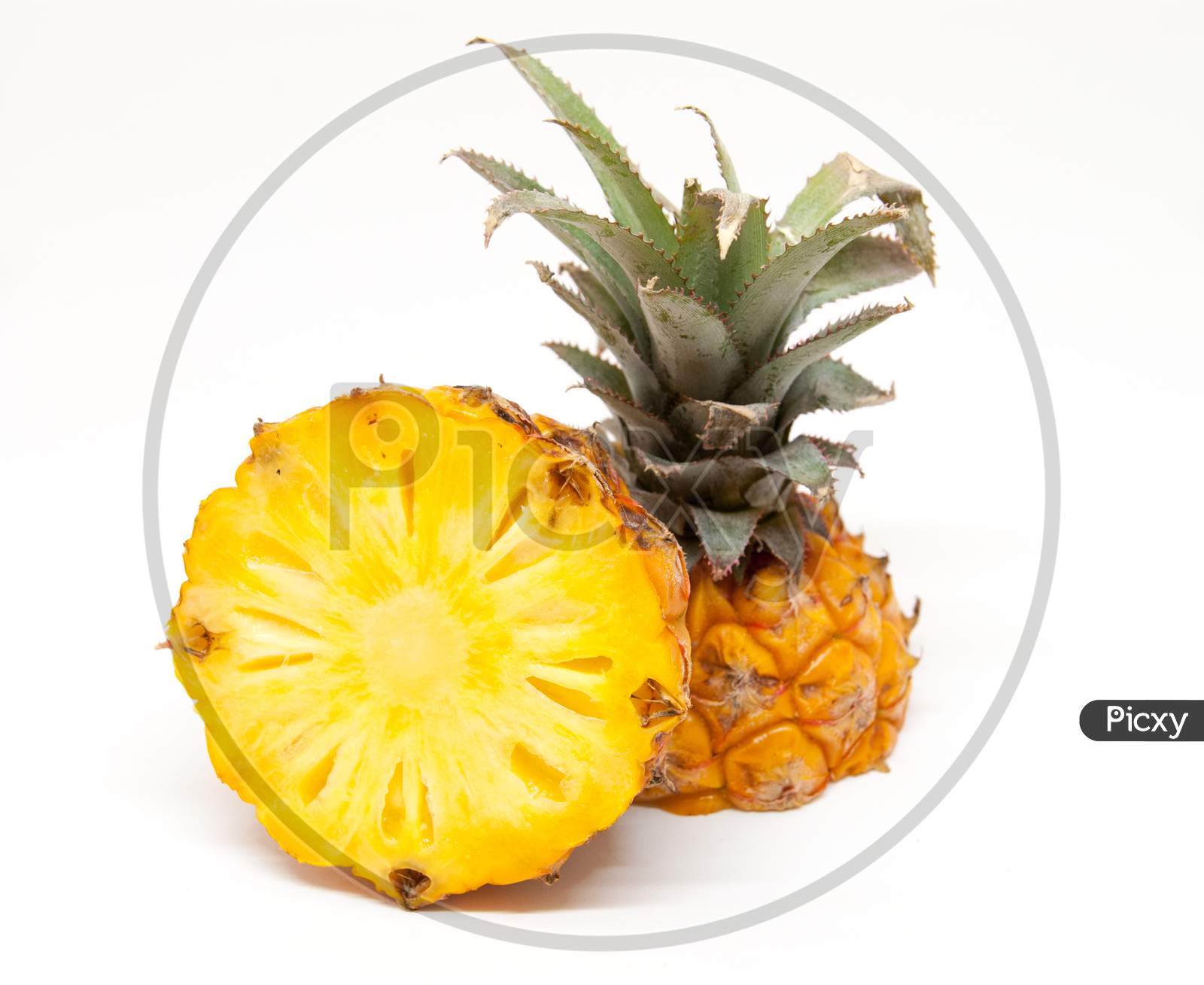 ripe tasty baby pineapple cut in half over white background