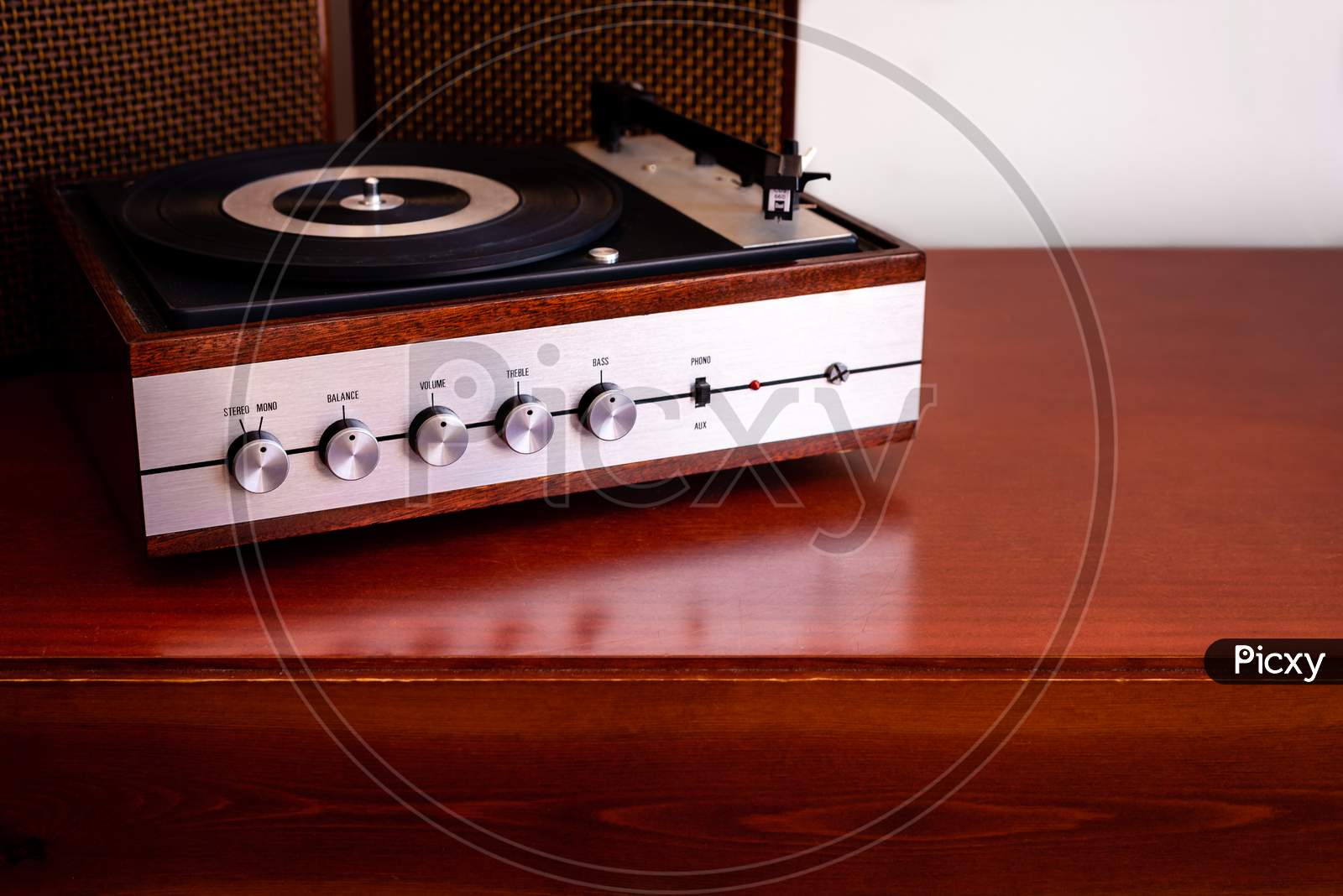 Vintage turntable made of wood with speakers on an old table