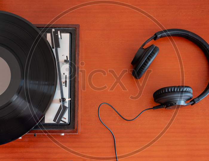 Vintage turntable made of wood with headphones on a table