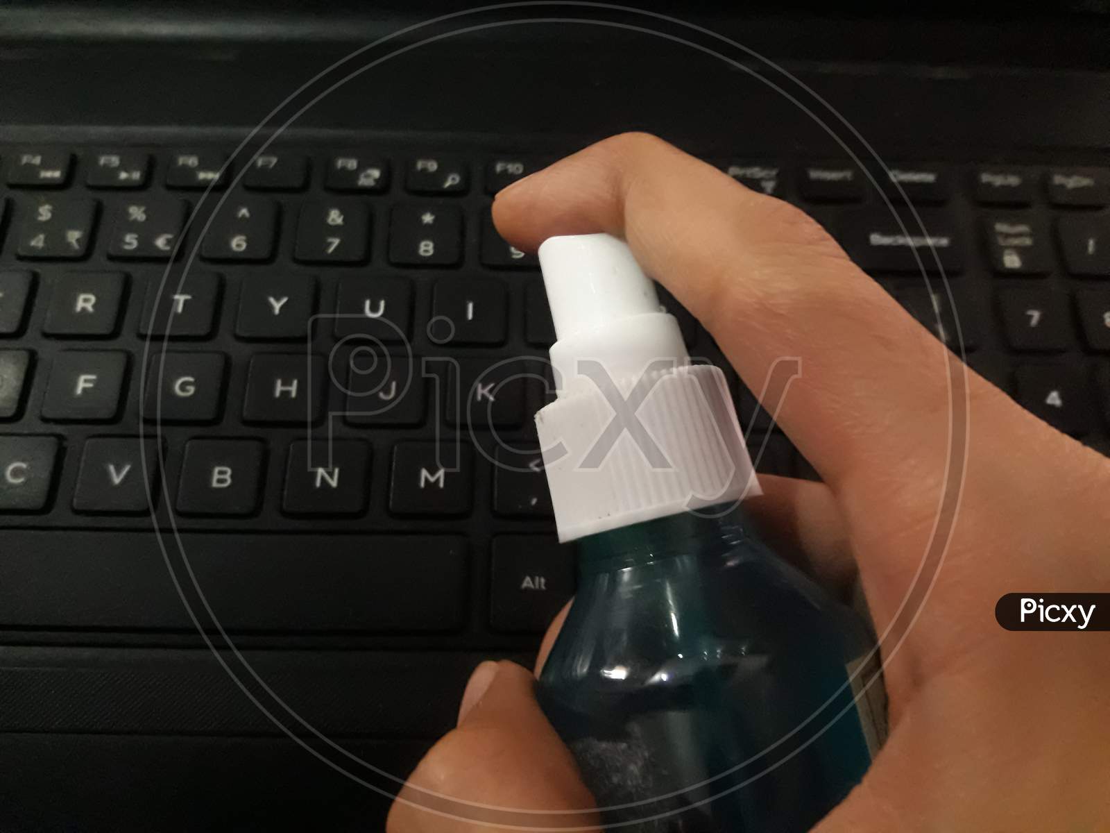 Sanitizing The Keyboard Of Laptop With Sanitizer to avoid the spread of coronavirus or covid 19