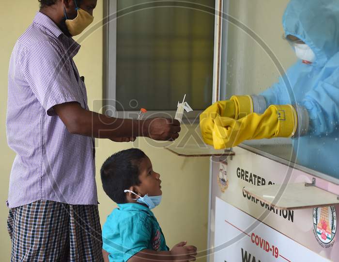Medics wearing protective suits collect swab samples for the COVID-19 test in Chennai