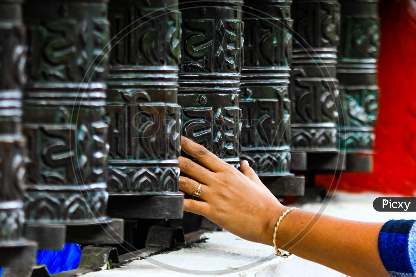 Buddhist Prayer Drums With Close-Up Mantras.The Female Hand Touches The Buddhist Prayer Drum, Nepal.