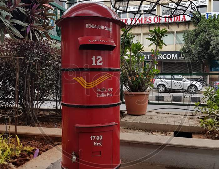A big red colored postbox that belongs to Indian Postal service at a public park