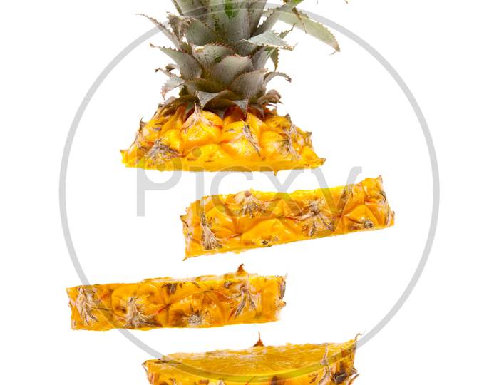 ripe delicious baby pineapple slices floating on white background