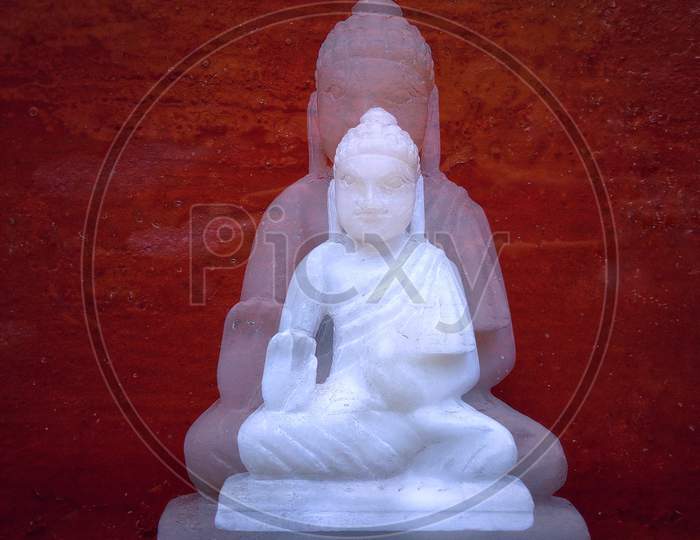 Little Buddha statue red background double exposed