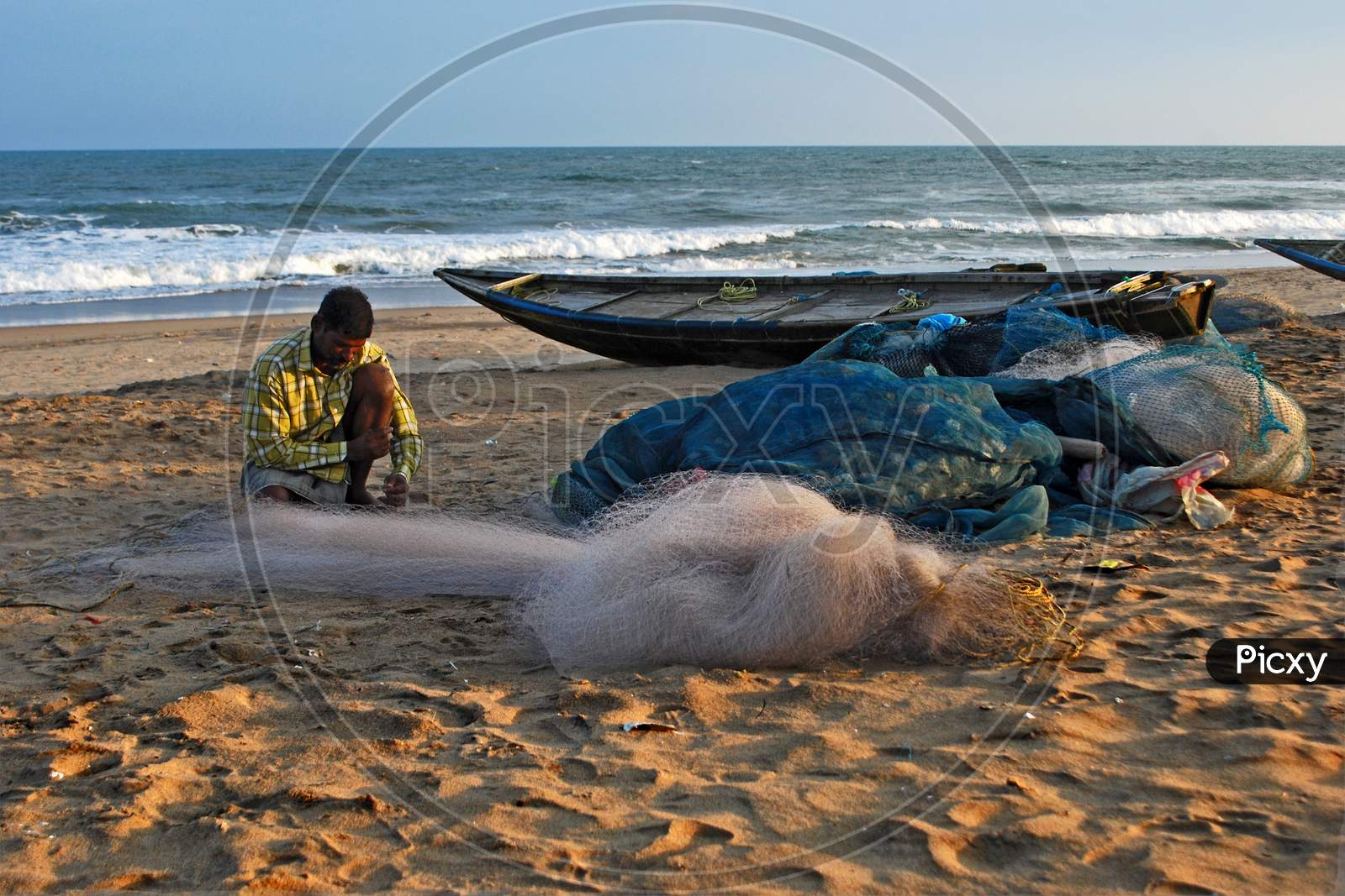 Fisherman working with a fishing net on the sea beach of Puri.
