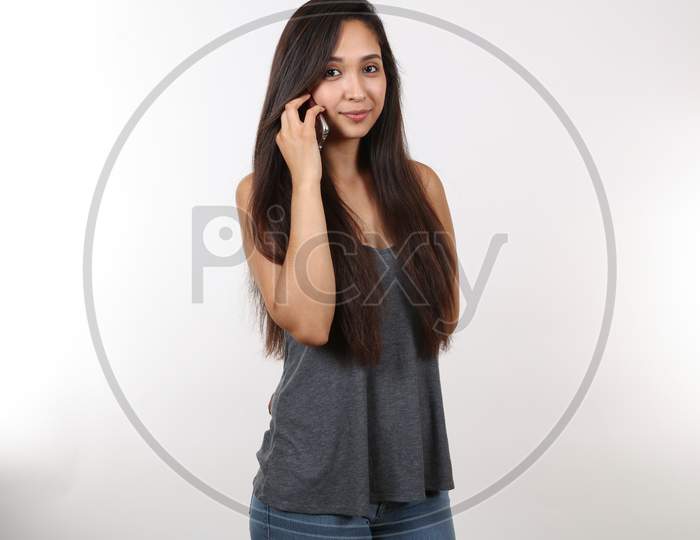 A Young Attractive Hispanic Female Holds Patiently On The Phone.