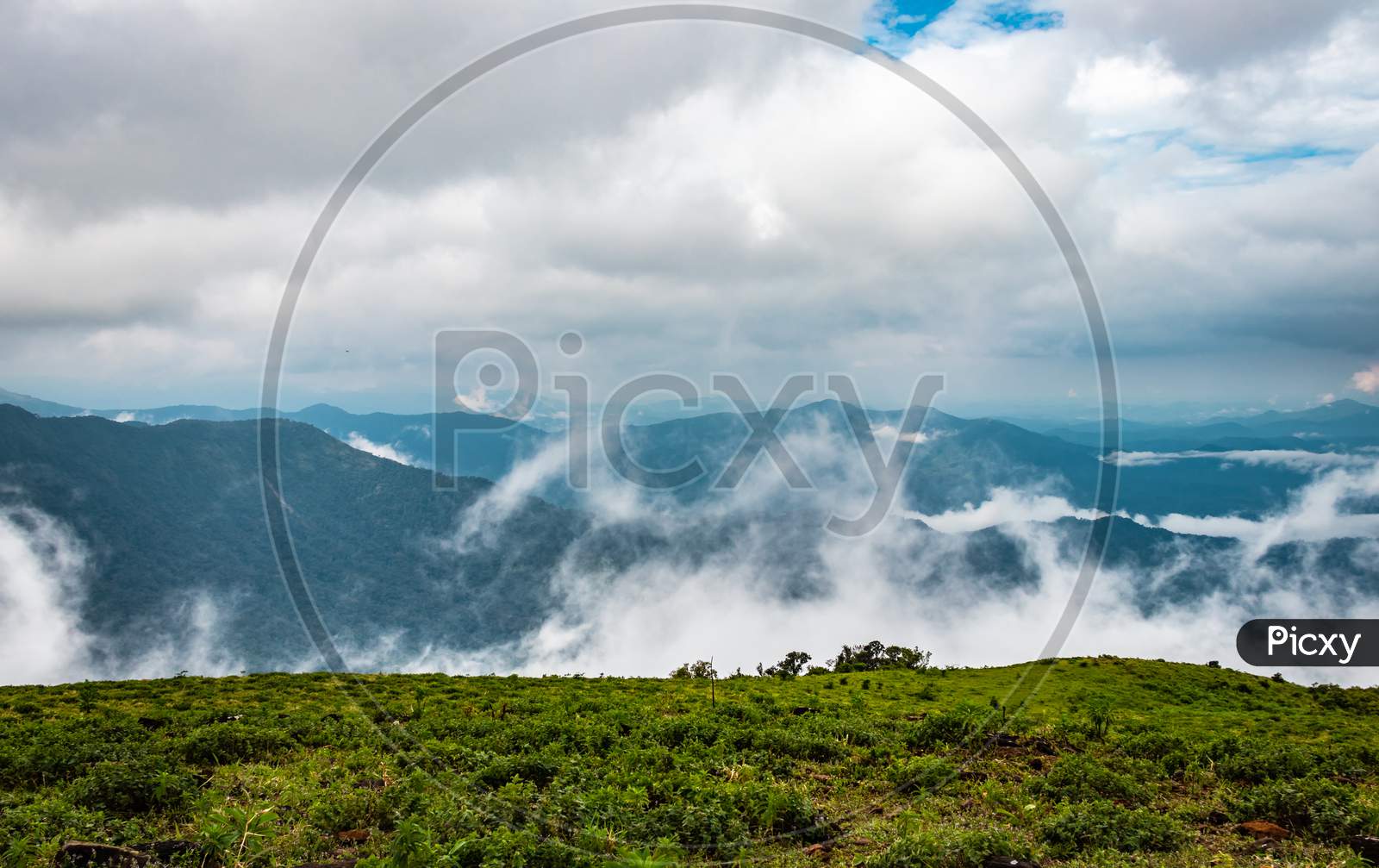Cloud layers on mountain horizon with green grass