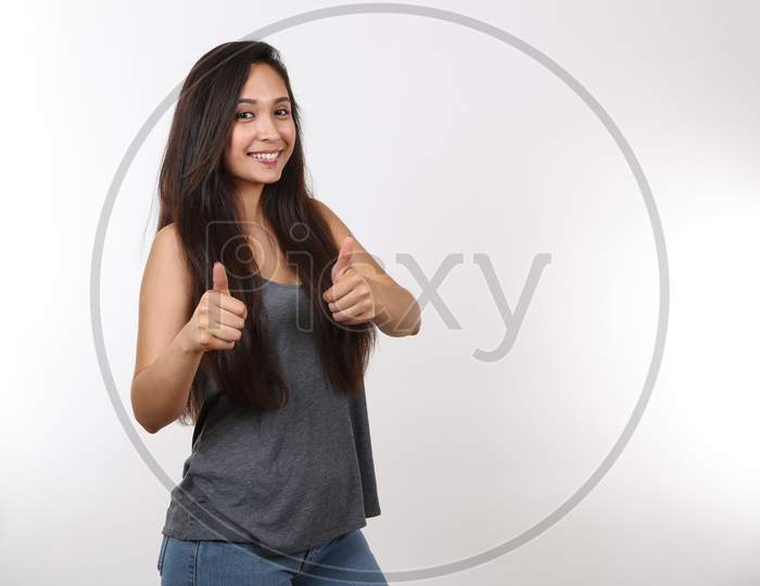 A Young Attractive Girl Wearing Jeans Gives Two Thumbs Up.
