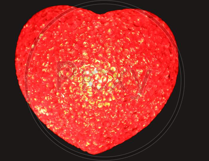 luluminous red love heart on black back ground
