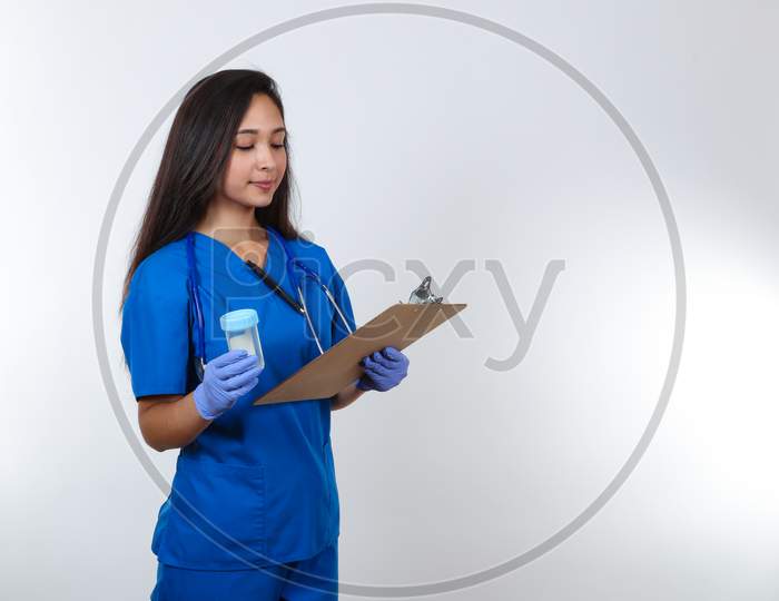 A Young Female Nurse In Blue Scrubs Prepares To Administer A Drug Test.