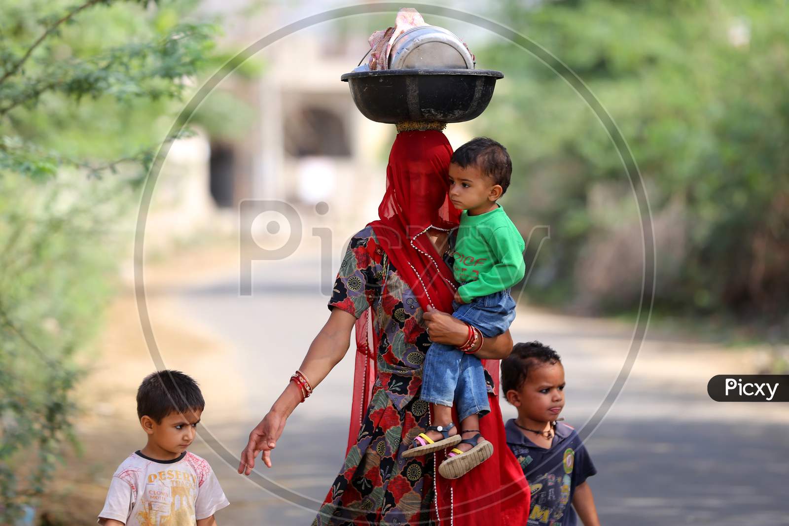 A woman walks with her children on the eve of Mother's day on the outskirts village of Ajmer, Rajasthan, India on 09 May 2020.