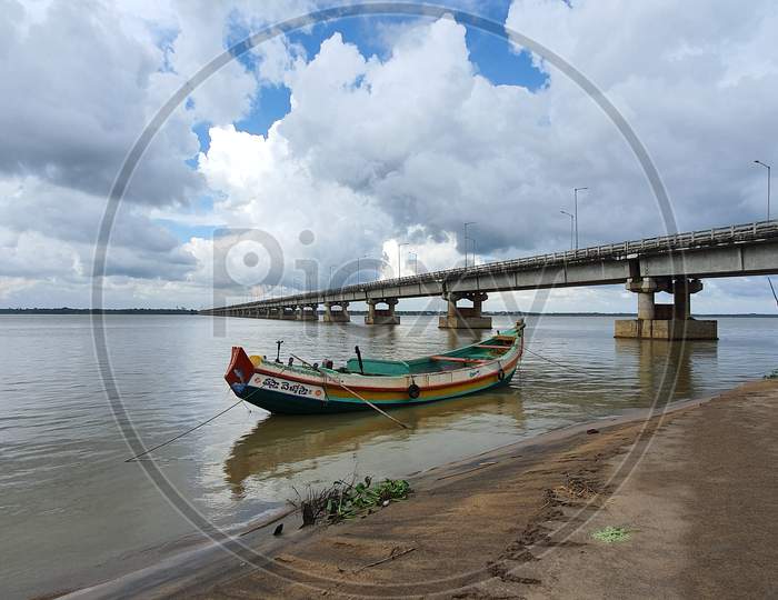 Wide view of beautiful boat against the backdrop of bridge on Godavari river