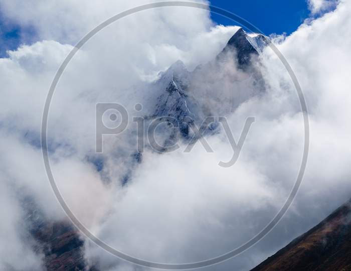 Machhapuchhre Mountain peak behind clouds