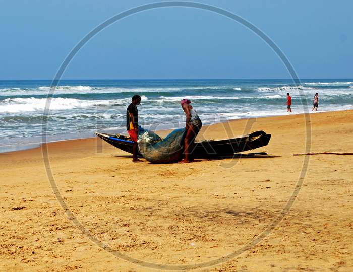 Fishermens working with a fishing net on the sea beach of Puri.