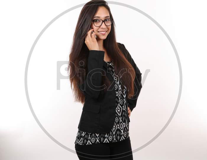 An Attractive Entrepreneur In Glasses Talks On Her Cell Phone As She Smiles.