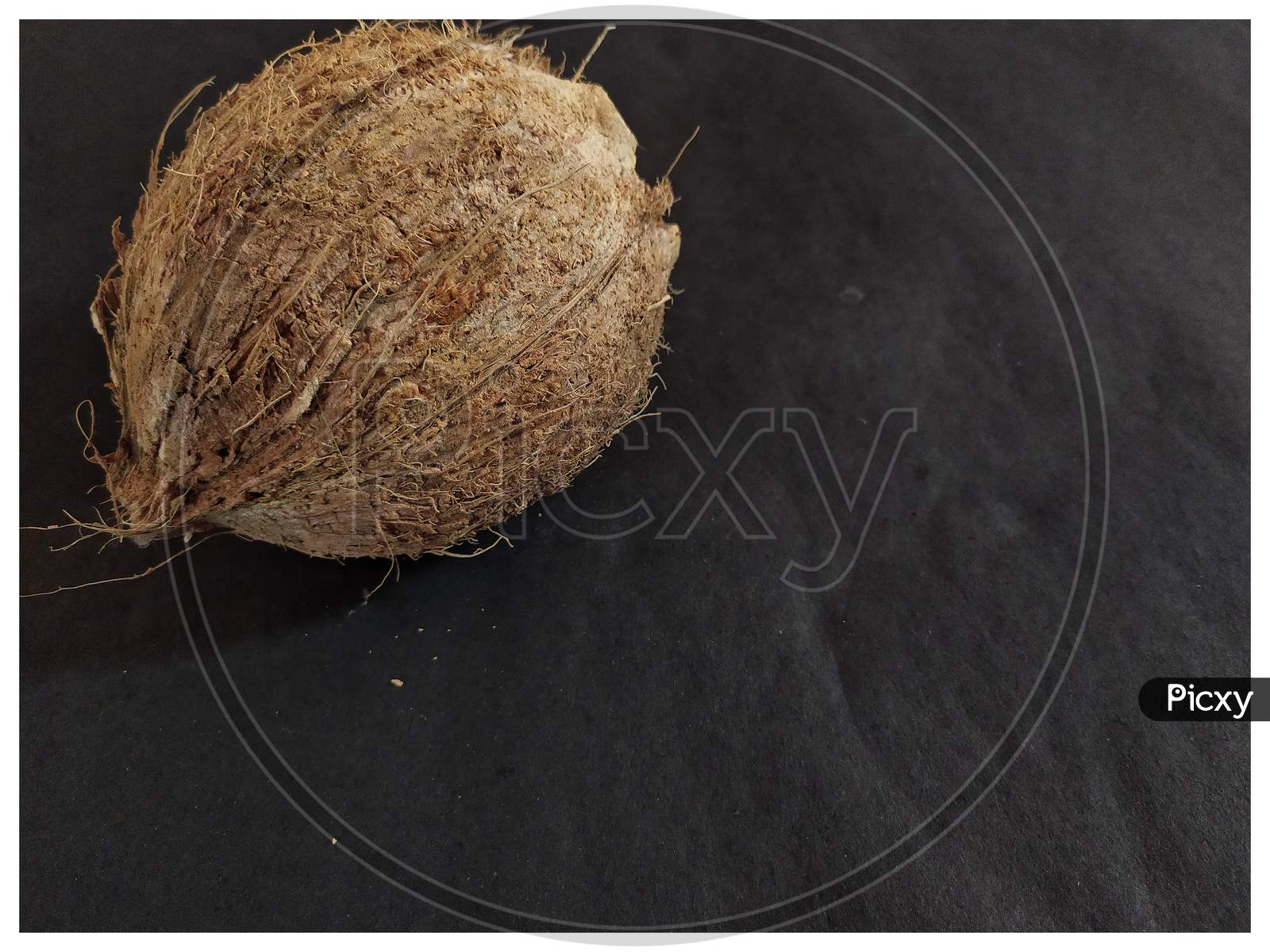 Peeled coconut on black background.