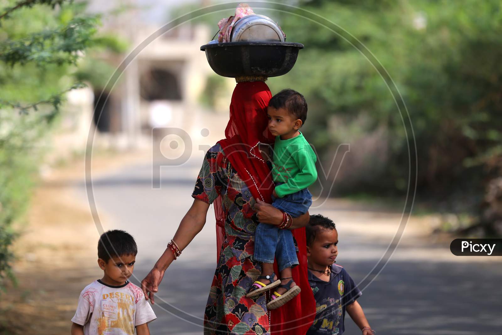A woman walks with her children on the eve of Mother's day on the outskirts village of Ajmer, Rajasthan, India on 09 May 2020.