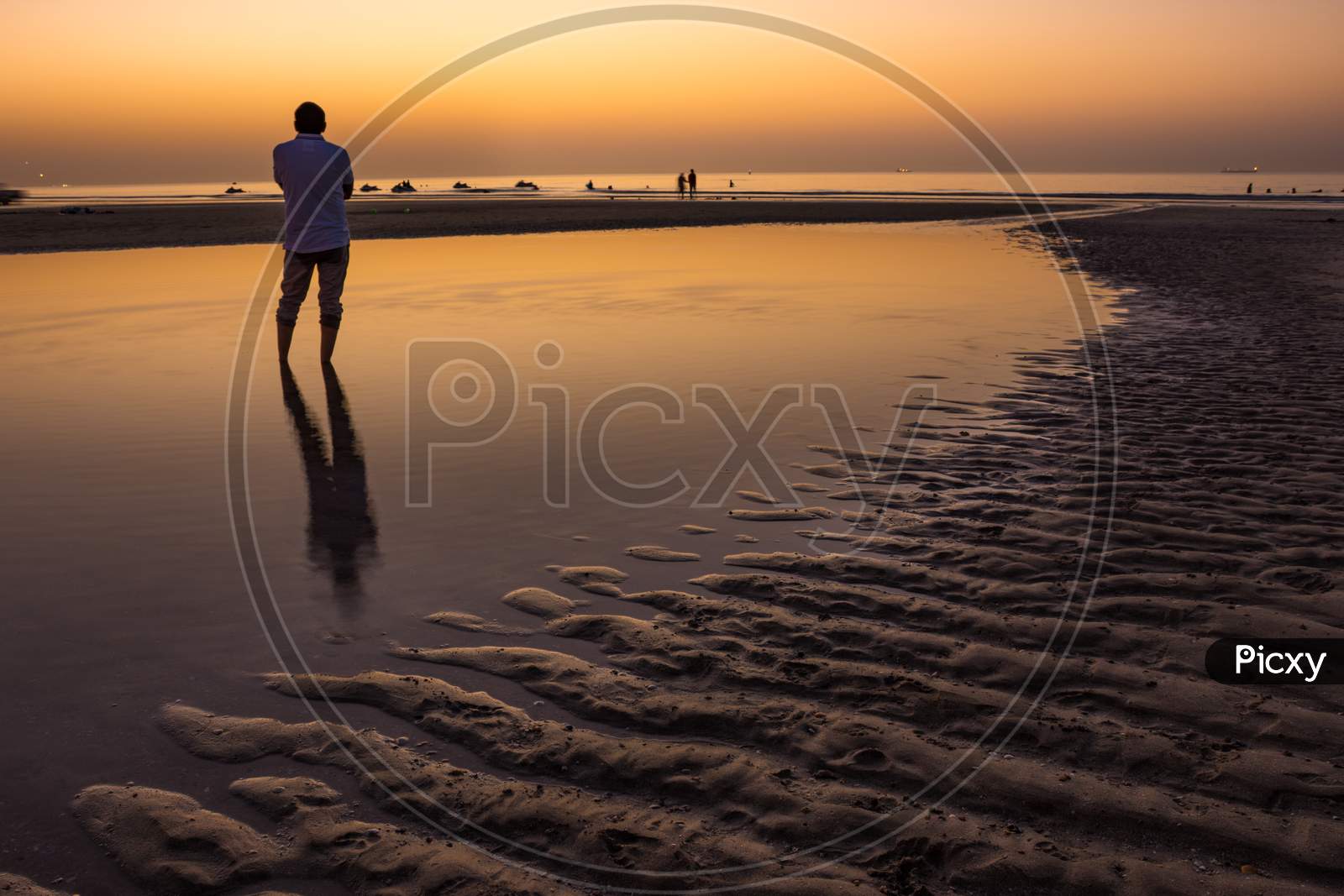 Sillhoute of an unrecognizable man during sunset in the beach of Oman.