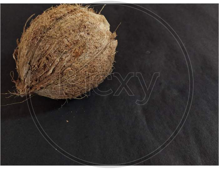 Peeled coconut on black background.