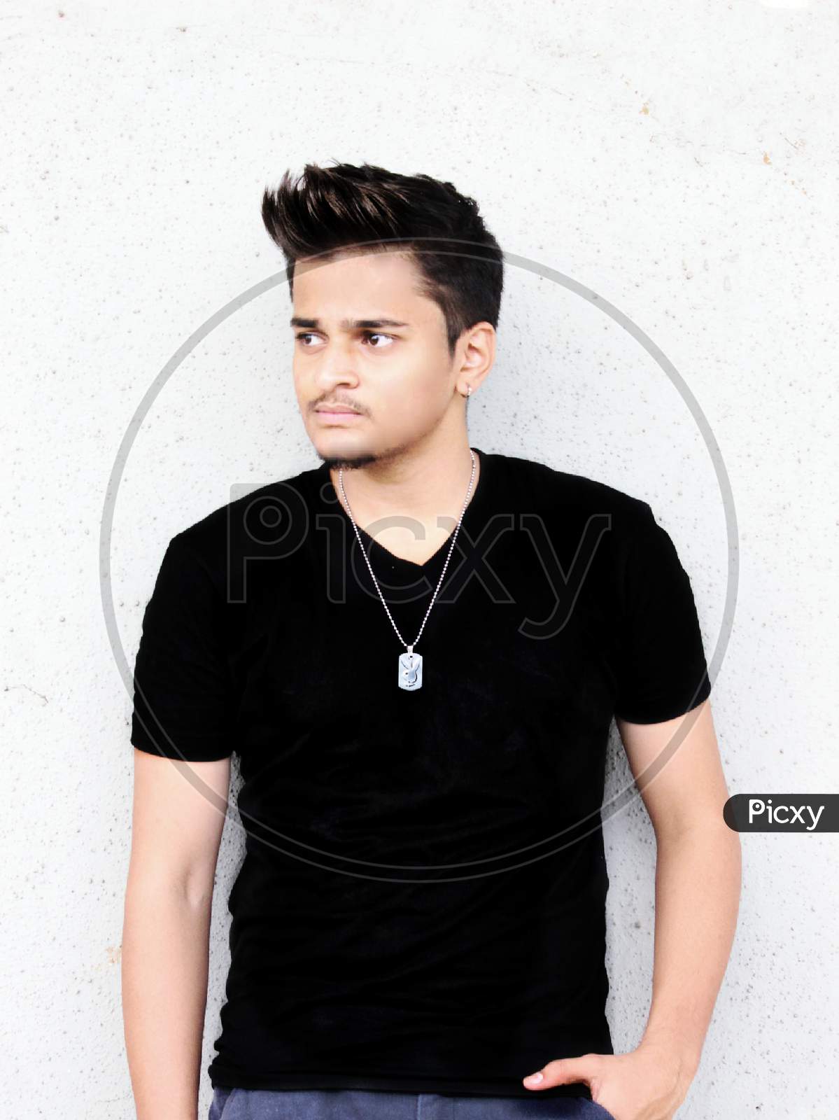 smart and handsome teenage boy standing wearing black t-shirt