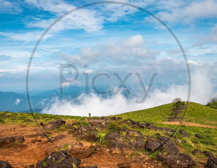 Cloud layers on mountain horizon with green grass