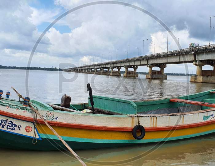 Fishing boat against the backdrop of scenic bridge on Godavari river in Yanam