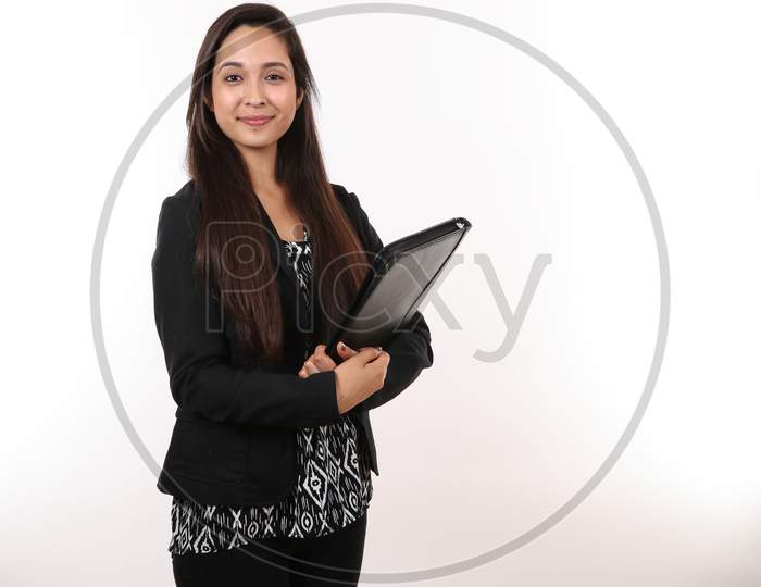 An Attractive Young Executive Assistant Holds Her Portfolio And Smiles.