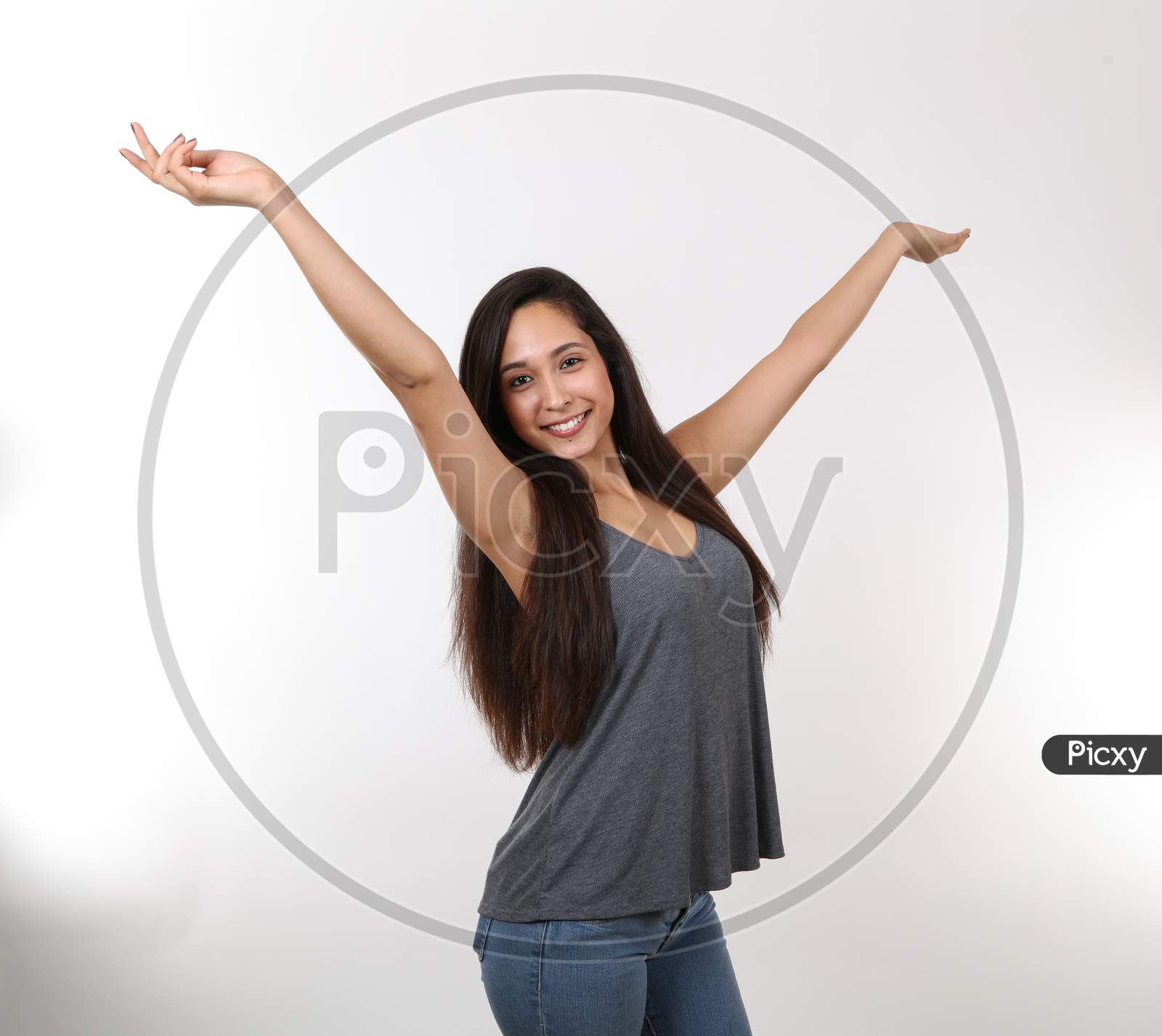 An Excited Hispanic Young Girl Throws Her Hands In The Air With Excitement.