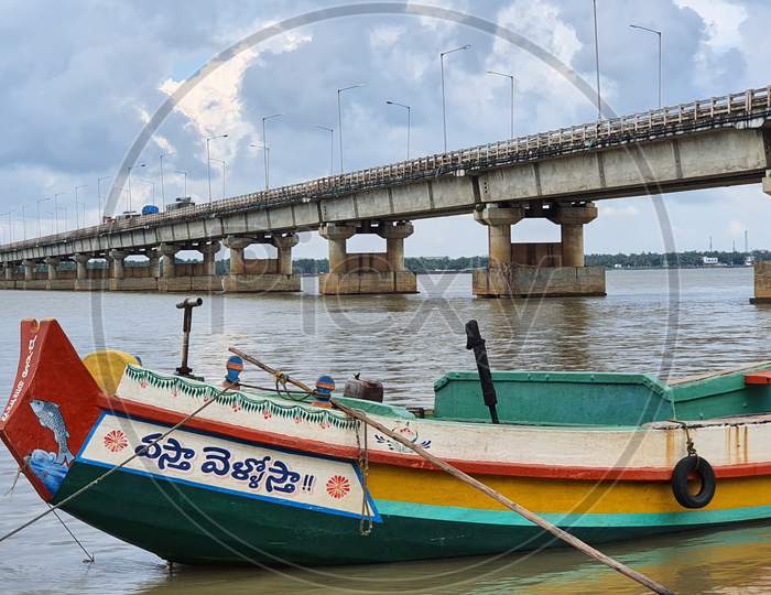 Fishing boat against the backdrop of bridge on Godavari river
