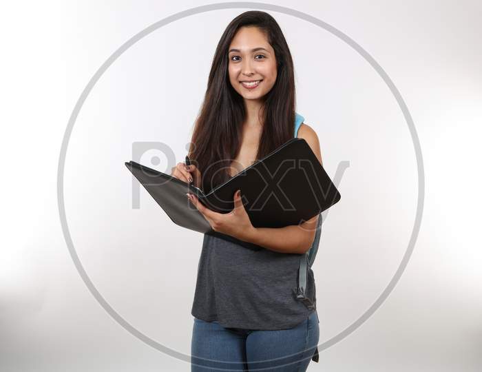 A Young Student Prepares To Take Notes In Her Black Portfolio While Holding Her Backpack.