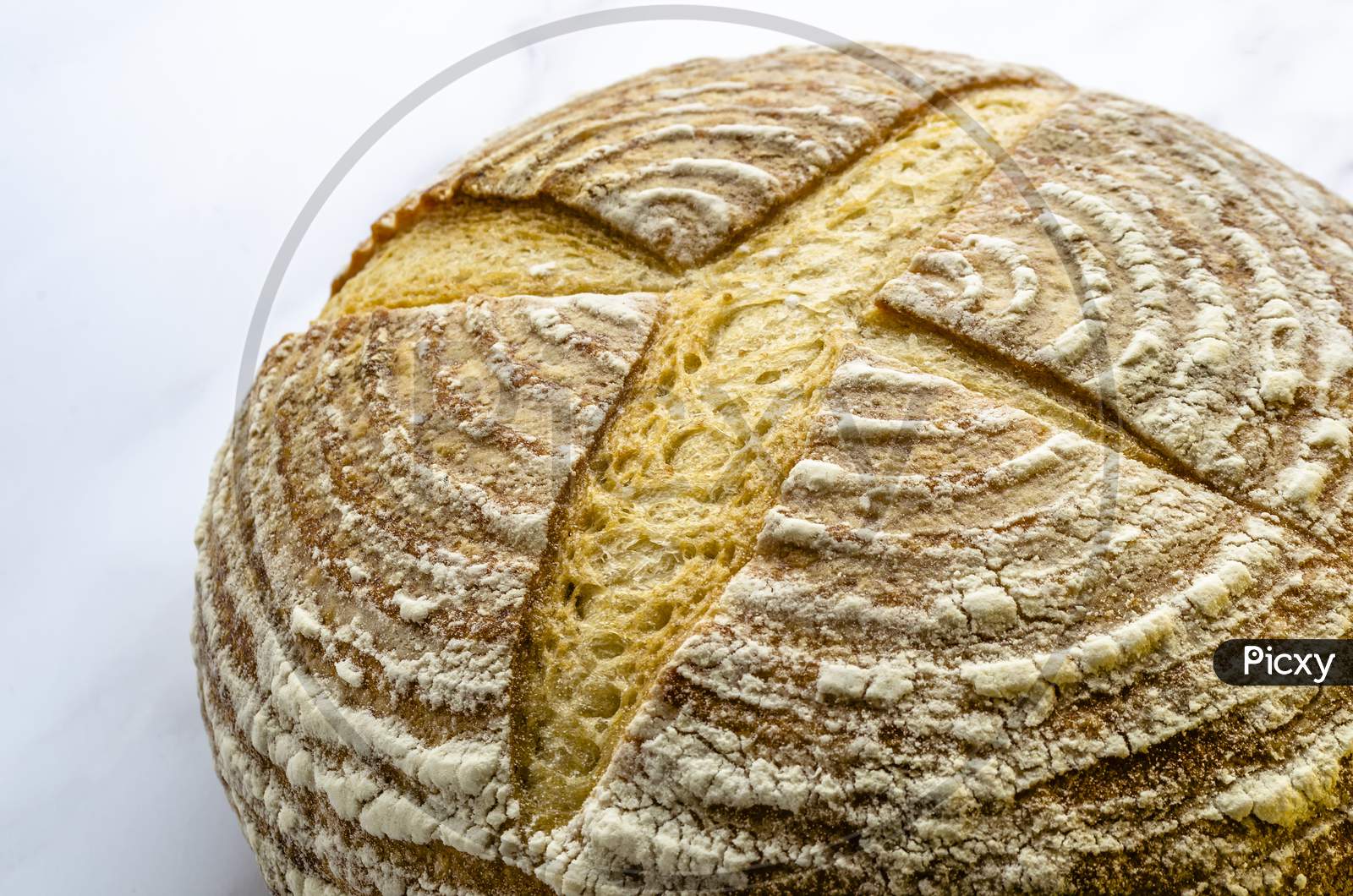 A loaf of freshly baked Sourdough bread on a plain background