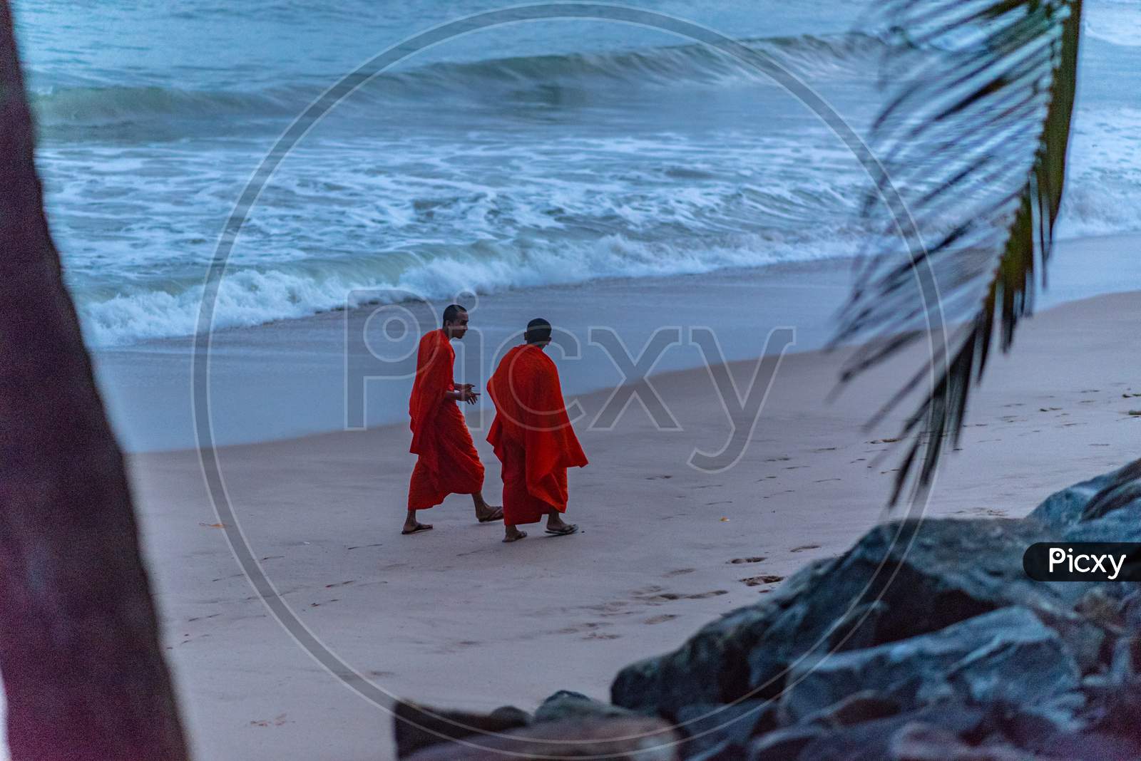 Monks walk the beach in Sunset in the beach of Tangalle, Sri Lanka