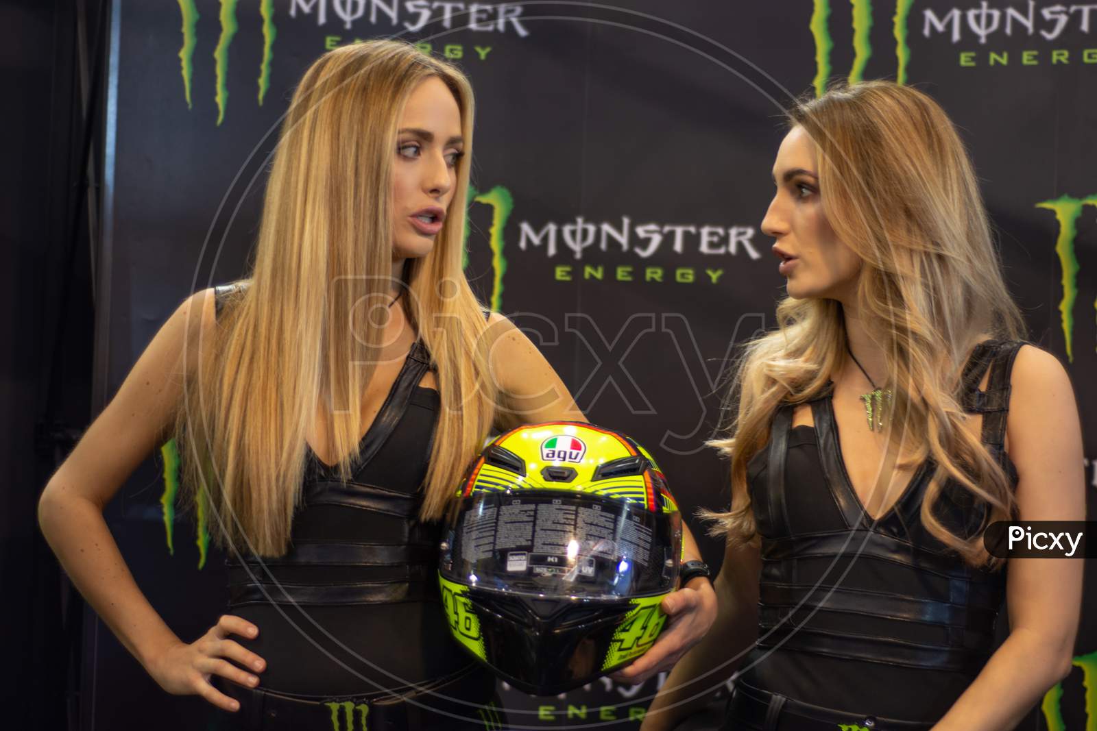 Beautiful Monster Energy girls pose with the motorcycle at Belgrade Car and Motor Show