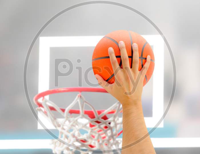Throwing the basket ball into the basket mesh