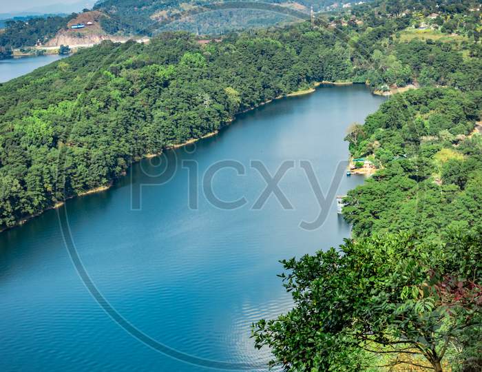Lake Serene Blue Water With Misty Mountains Aerial Image Is Taken At Umiam Lake Shillong Meghalaya India. It Is Showing The Breathtaking Beauty Of Nature.