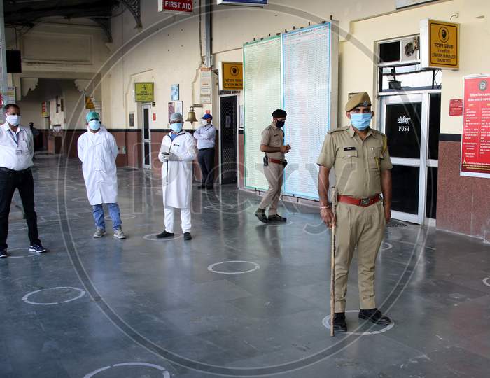 Security personnel and medics stand near a special train which will be on-boarded by migrants to Bihar State from Ajmer railway station during a government-imposed nationwide lockdown as a preventive measure against the COVID-19 or coronavirus, in Ajmer on May 10, 2020.