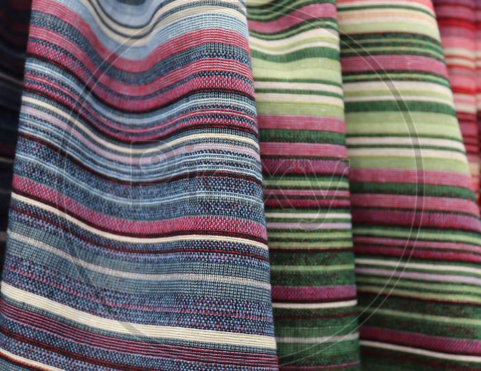 Close up view on colorful hanging and folded  fabrics and textiles in high resolution found on a fabrics market