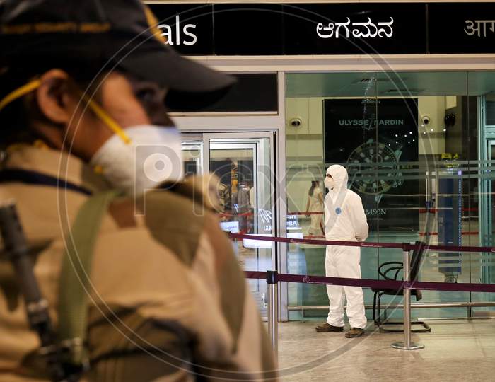 Airport security personnel stand guard at the Kempegowda International Airport in Bangalore, India, May 11, 2020. Three hundred twenty six passengers stranded in the UK due to the covid-19 lockdown arrived in an Air India flight at the break of dawn.