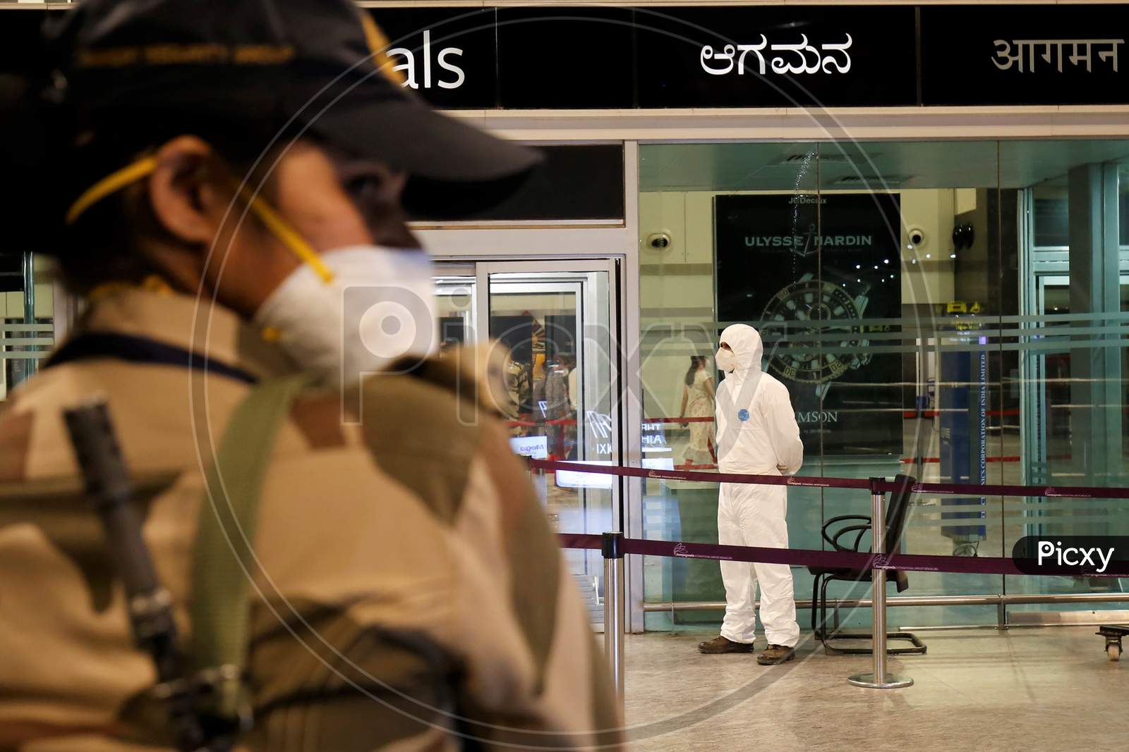 Airport security personnel stand guard at the Kempegowda International Airport in Bangalore, India, May 11, 2020. Three hundred twenty six passengers stranded in the UK due to the covid-19 lockdown arrived in an Air India flight at the break of dawn.