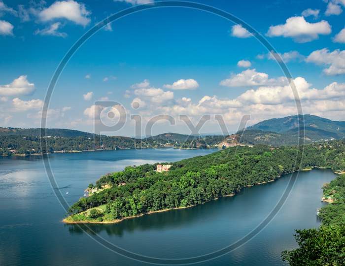 Lake Serene Blue Water With Misty Mountains Aerial Image Is Taken At Umiam Lake Shillong Meghalaya India. It Is Showing The Breathtaking Beauty Of Nature.
