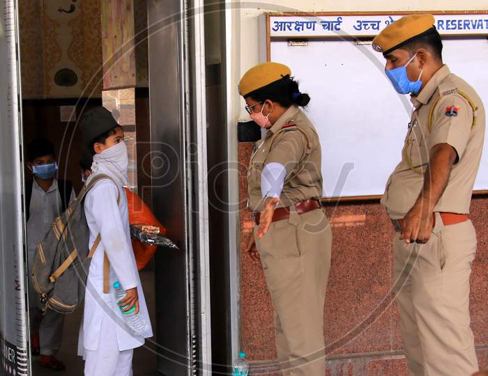  Security personnel direct migrants towards a special train which will be on-boarded by migrants to Bihar State from Ajmer railway station during a government-imposed nationwide lockdown as a preventive measure against the COVID-19 or coronavirus, in Ajmer on May 10, 2020.