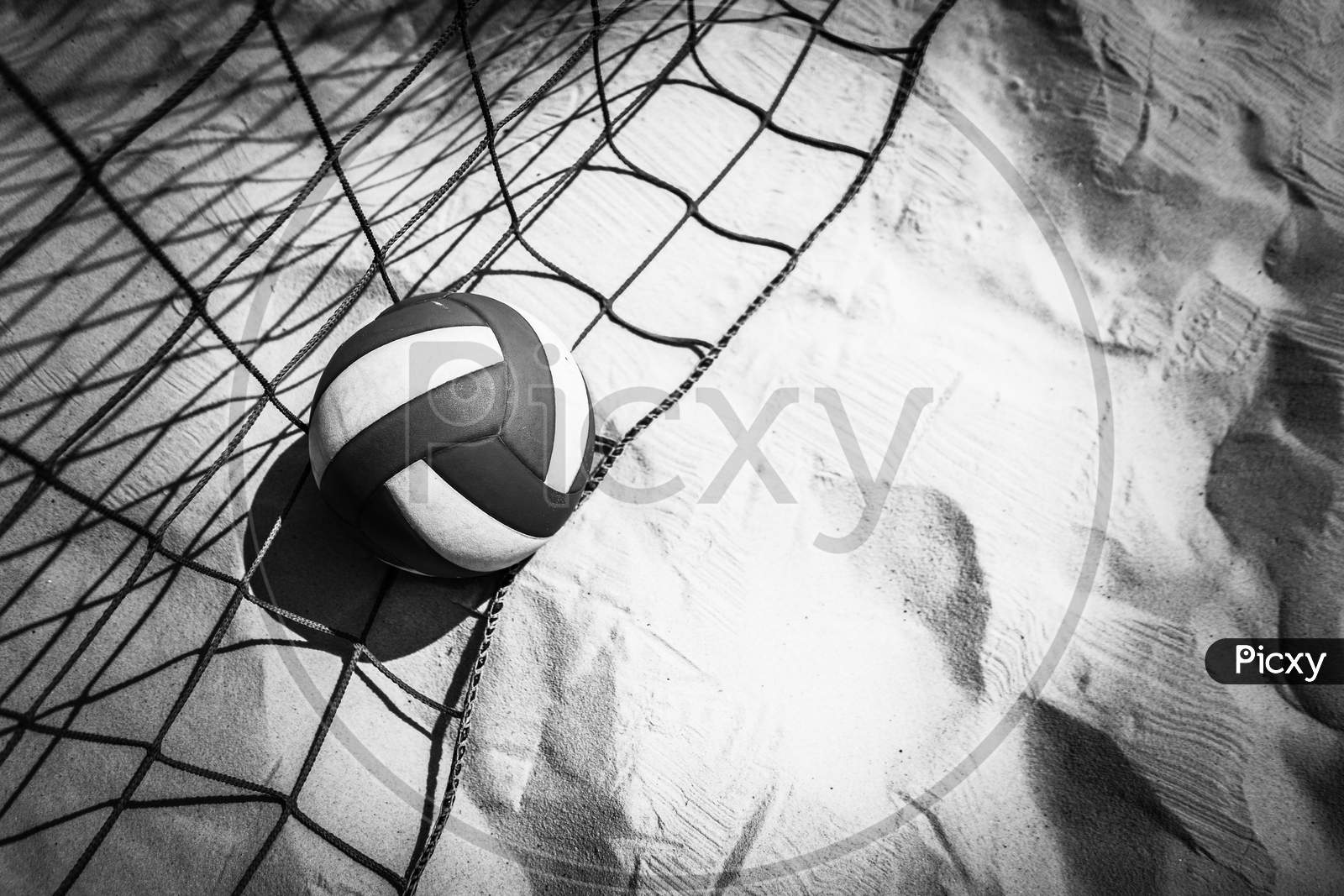 Volleyball and netting are on the beach Black and white view