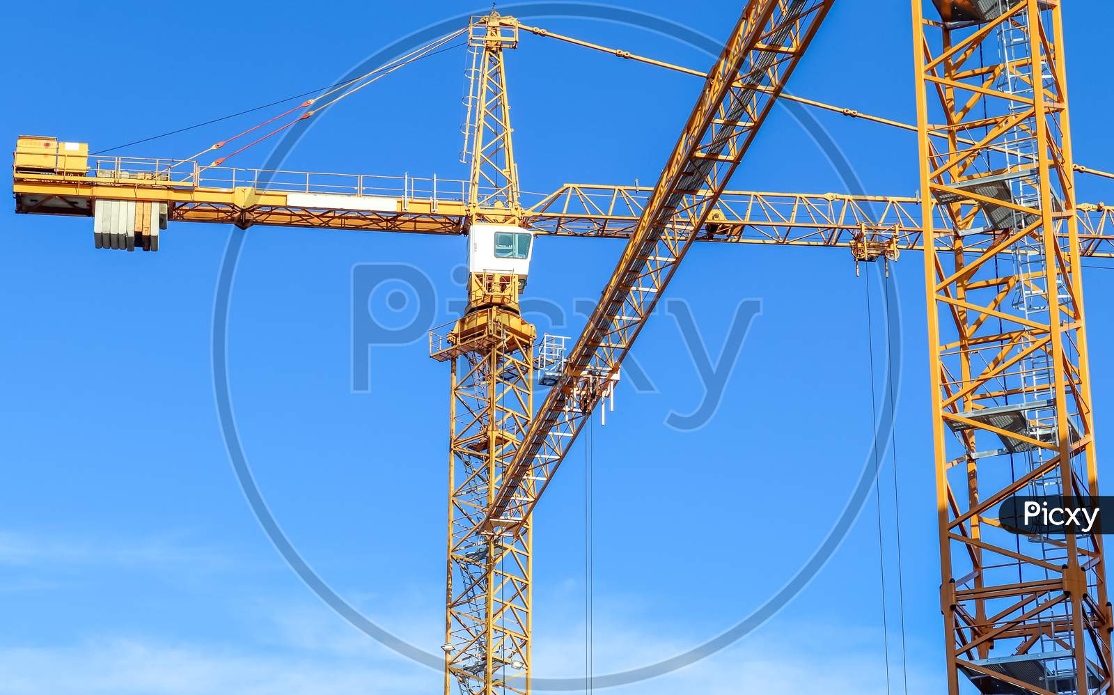 Big yellow cranes at a construction site on a sunny day