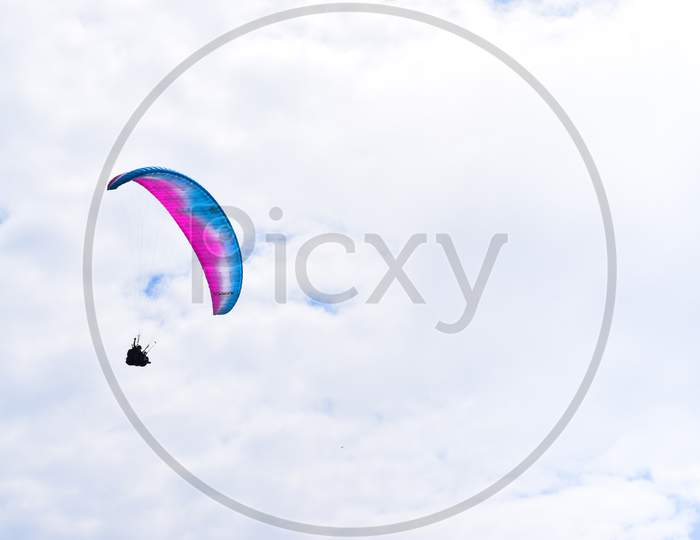 Paragliding Below The Cloudy Sky