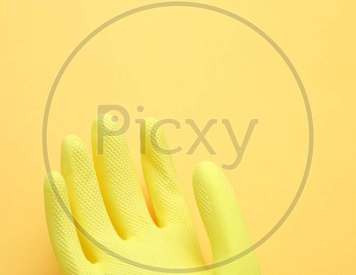 Hand In Yellow Glove Isolated On Yellow Background,Top View